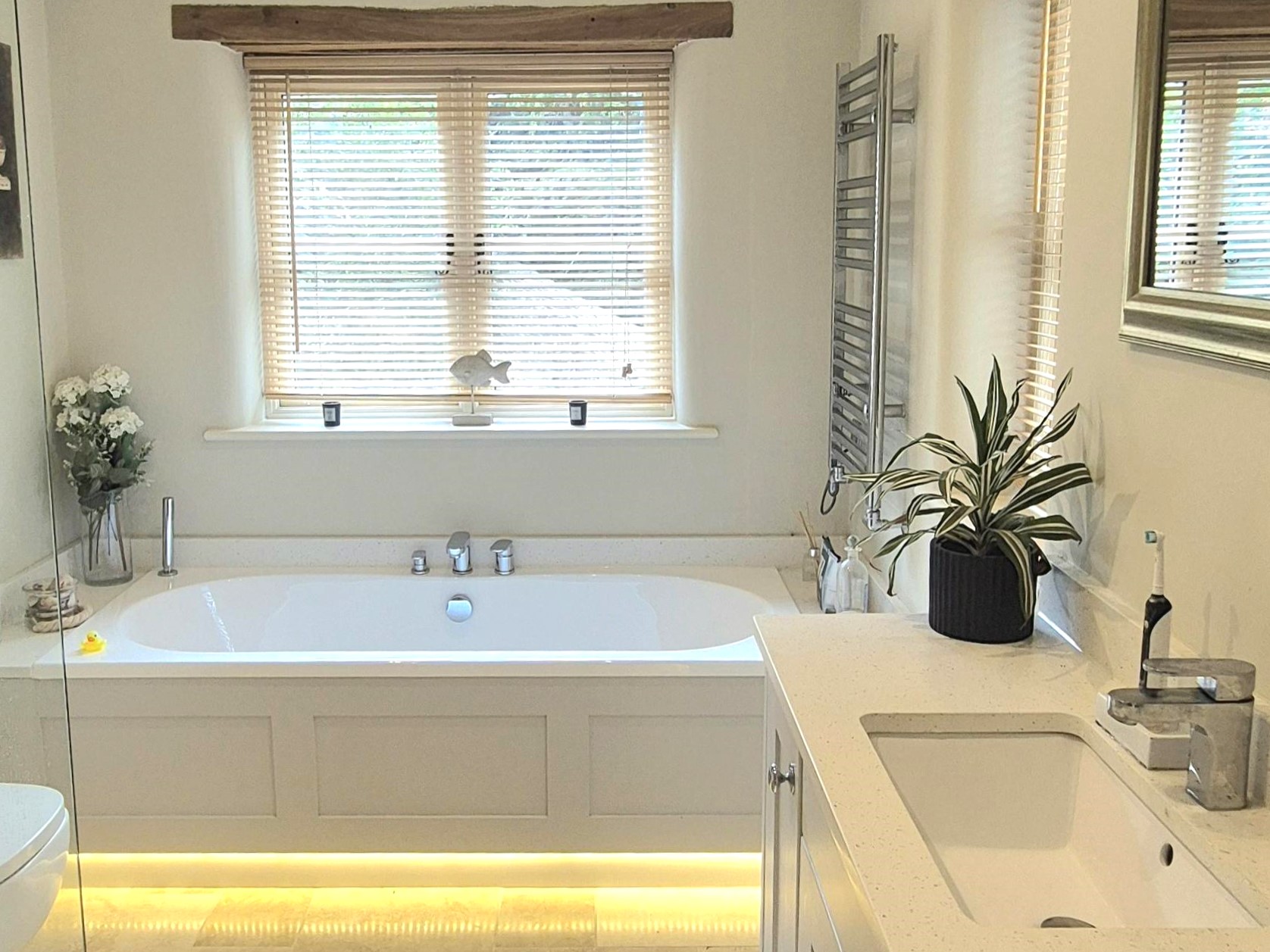 Navy panelled bathroom with freestanding bath and brass fittings