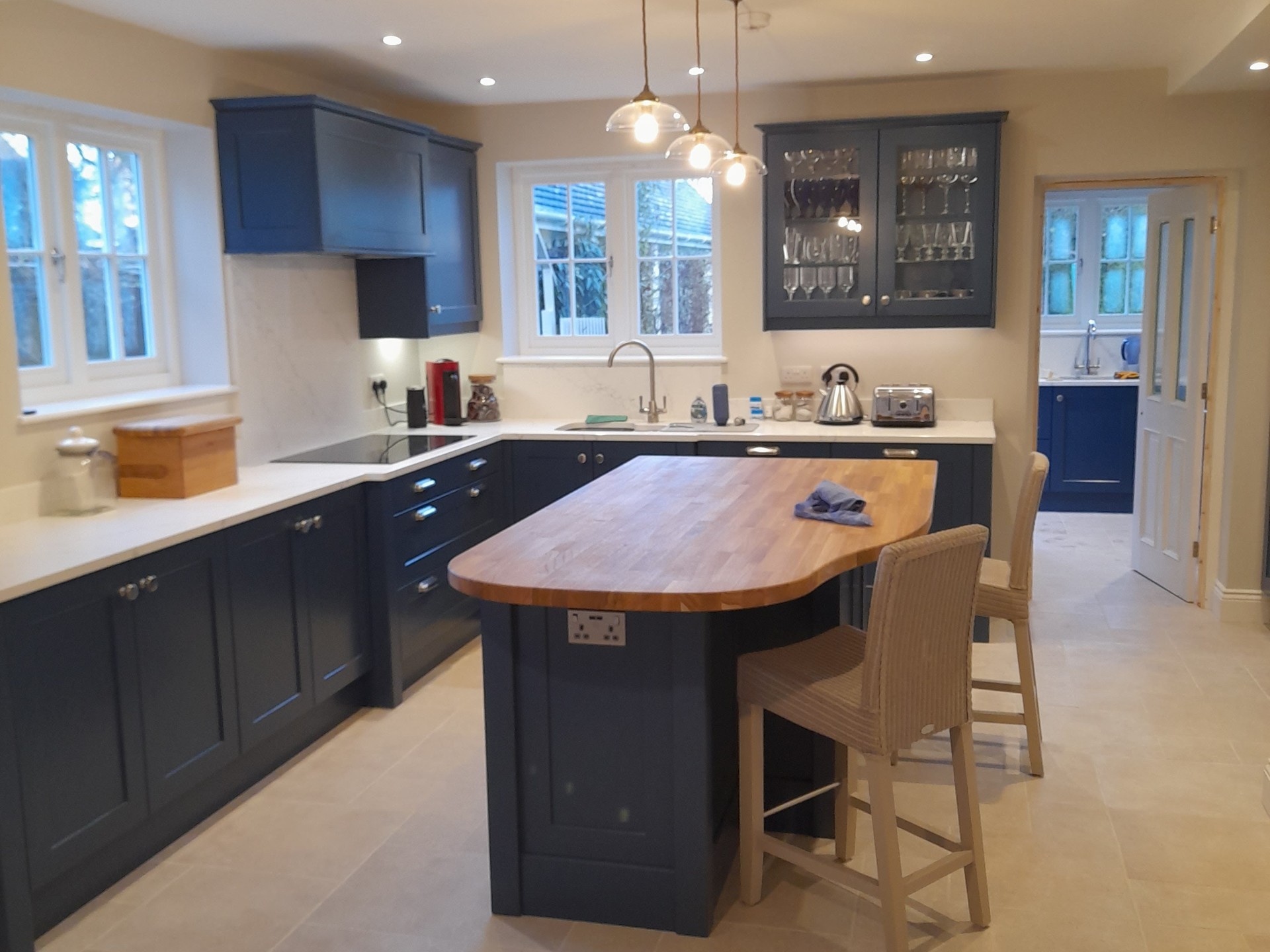 Navy shaker kitchen with oak island and white worktops